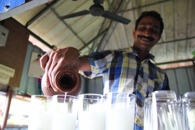 Dev Anant pours a round of toddy, coconut palm wine, in his bar in Kerala's backwaters.